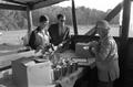 Photograph: [Opal Wilcox selling cane syrup to two individuals]