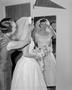 Photograph: [Marjorie Lee Hitch putting the veil on her daughter's head]