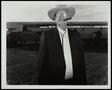 Photograph: [An unknown man at a polo match, wearing a suit]