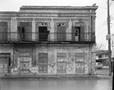 Photograph: [Side of a heavily dilapidated two-story building]