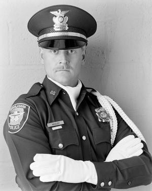 Primary view of object titled '[Fort Worth police officer Rick Whaley with his arms crossed]'.
