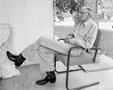 Photograph: [Uncle Roland sitting in a chair on a porch]