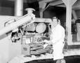 Photograph: [Engineer posing with tools by a large machine]