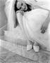 Photograph: [Bridal model with her face resting on her knee]