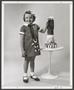 Photograph: [Little girl posing with figurine]