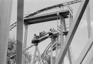 Primary view of object titled '[An amusement ride with passengers riding down curving tracks at Six Flags Over Texas in Arlington]'.