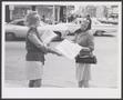 Thumbnail image of item number 1 in: '[Photograph of a woman handing out a Meacham's Fashion magazine]'.