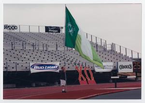 Primary view of object titled '[A Talons member holding the UNT flag during the homecoming game against Utah State]'.