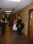 Photograph: [Four women standing near doors in a brick hallway]