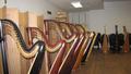 Photograph: [A row of harps next to cardboard boxes and chairs]