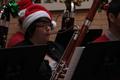 Primary view of [A person playing a bassoon adorned with an ornament and tinsel]