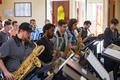 Primary view of [A row of men playing saxophones in a crowded room]