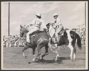 Primary view of object titled '[Two individuals riding horses during a livestock show]'.