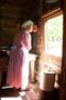 Photograph: [Pioneer woman looking out window]