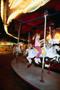 Photograph: [A child riding a carousel at night at the North Texas State Fair]