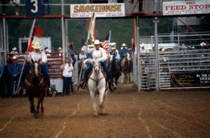Primary view of object titled '[Two people on horseback carrying flags at the North Texas State Fair]'.