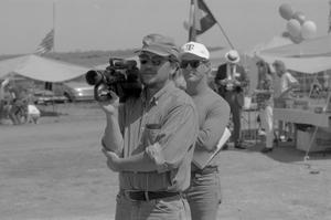 Primary view of object titled '[Two men, one with a camera, at the Branch Davidian Annual Reunion]'.