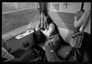 Primary view of object titled '[Man sleeping on a train]'.