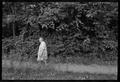 Photograph: [Elderly woman walking through the woods in a flower dress]