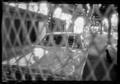 Photograph: [Car behind a wire fence]