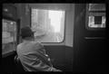 Photograph: [Man looking out of a train window]