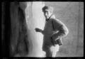 Photograph: [Man in a coat standing next to a large block of ice]