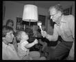 Photograph: [Man holding a toy in front of a baby]