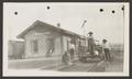 Thumbnail image of item number 1 in: '[Men standing on train tracks next to a building]'.