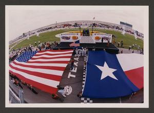 Primary view of object titled '[The United States and Texas State flags being unfurled]'.