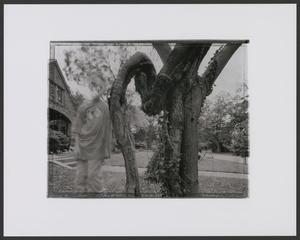 Primary view of object titled '[Double exposure of a young boy standing next to a tree]'.