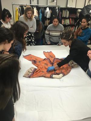 Primary view of object titled '[Students examining a nineteenth-century Chinese garment]'.