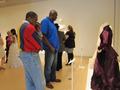 Primary view of [Visitors observing a historic purple wedding dress]