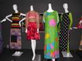 Photograph: [Four garments on display at exhibit]