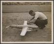 Thumbnail image of item number 1 in: '[Technician preparing a Forster-powered model airplane outdoors]'.