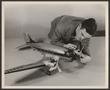 Thumbnail image of item number 1 in: '[A technician readying a model of a DC-3 airliner]'.