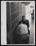 Photograph: [Two men crouched next to the bars of a jail cell]