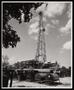 Photograph: [An oil derrick surrounded by trees]