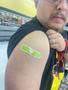Photograph: [A Man's Shoulder with a Green Band-Aid Covering the Site of a COVID-…