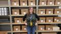 Thumbnail image of item number 1 in: '[Amy San Antonio standing in front of archival boxes]'.