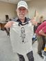 Primary view of [Steve Brooks holding up t-shirt of his design of Willie Nelson]