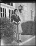 Photograph: [Young woman standing outside a door]