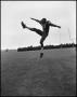 Photograph: [Football Player No. 87 in a Kicking Position Midair, September 1962]