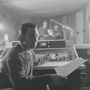 Primary view of object titled '[A man holding paper beside recording equipment, 3]'.