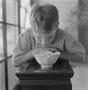 Photograph: [A boy looking into a bowl, 2]