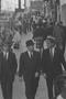 Photograph: [Three men walking down a crowded street, 3]