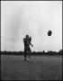 Photograph: [Football Player No. 16 Running towards the Football Flying through t…