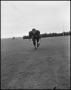 Photograph: [Football Player No. 64 Running Low on the Field, September 1962]