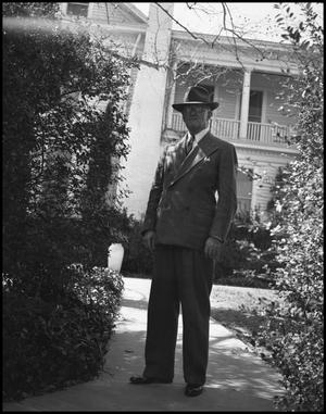 Primary view of object titled '[President McConnell in front of a house]'.