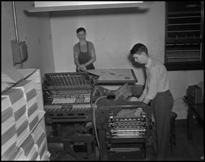 Primary view of object titled '[Two Young Men at the Printing Press]'.
