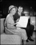 Photograph: [Dr. Matthews and Mrs. Myrtle Hollander with Book]